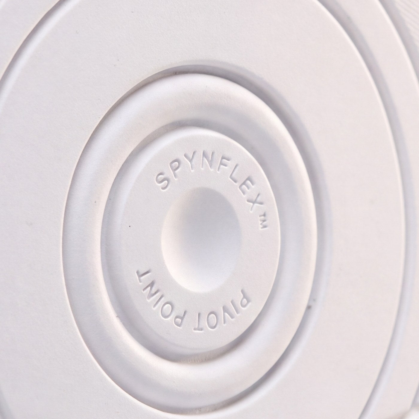 The SPYNFLEX® pivot disc in close-up, showing the moulded mark and the rings around it.