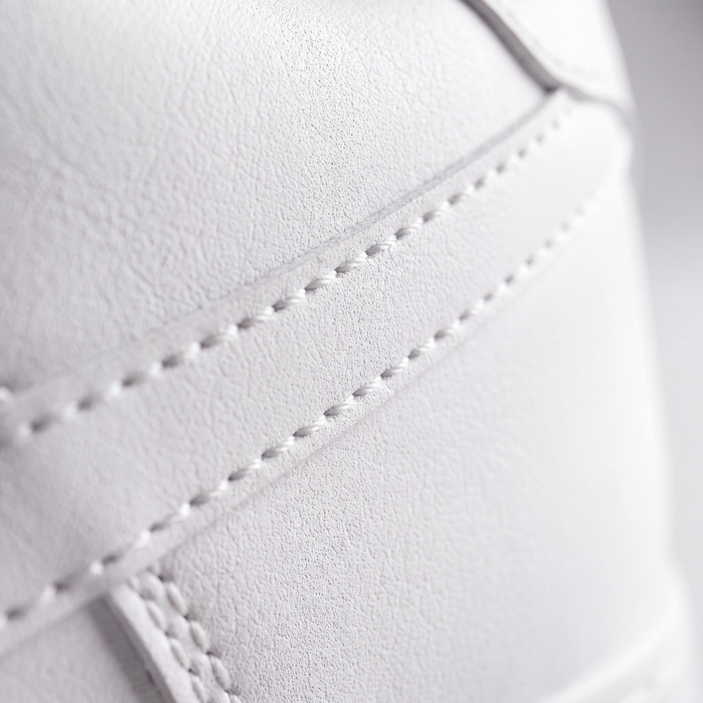 A stitched panel seam on the premium microfibre upper, in close-up.
