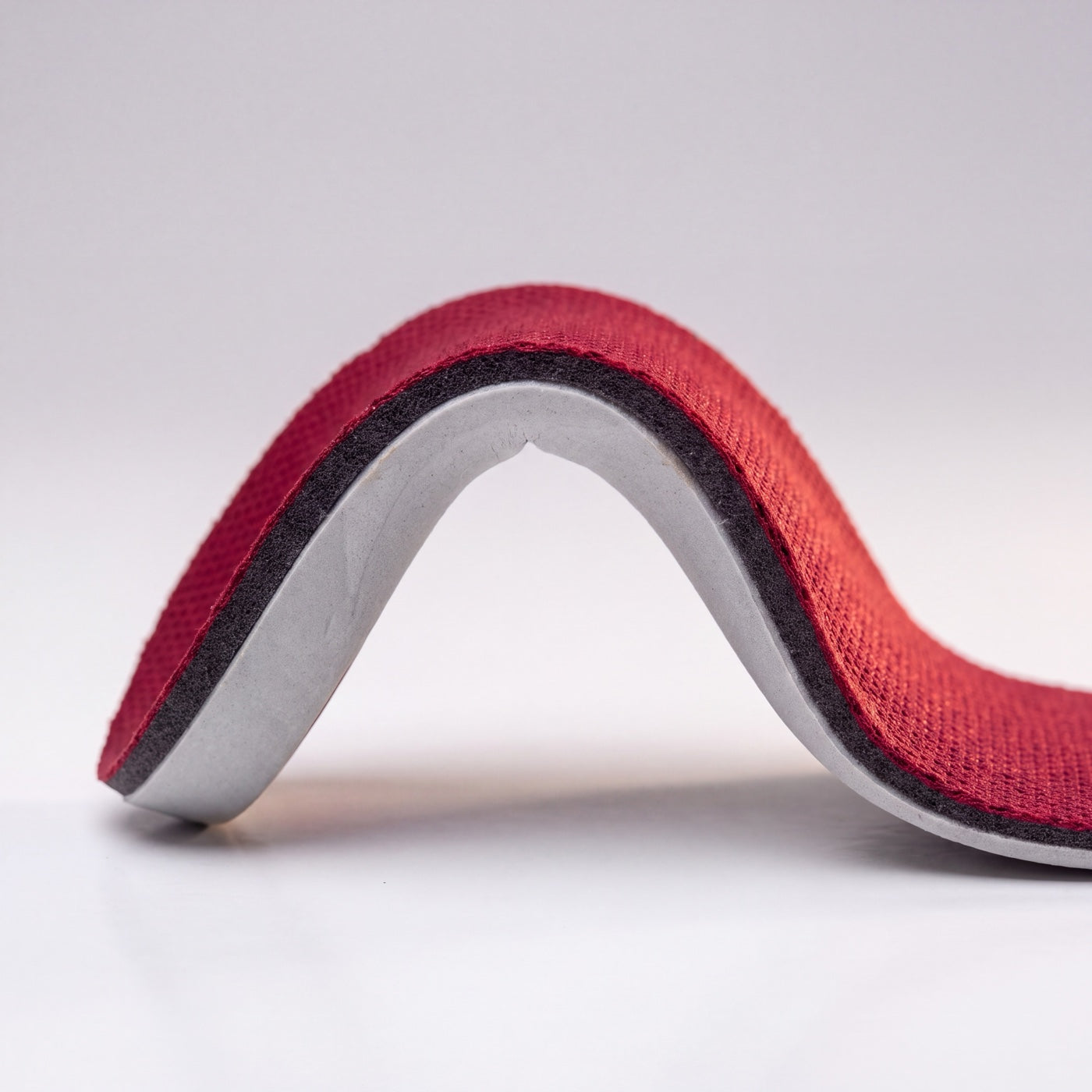 The GROOVECLOUD® insole flexed, showing its layers along the curve.